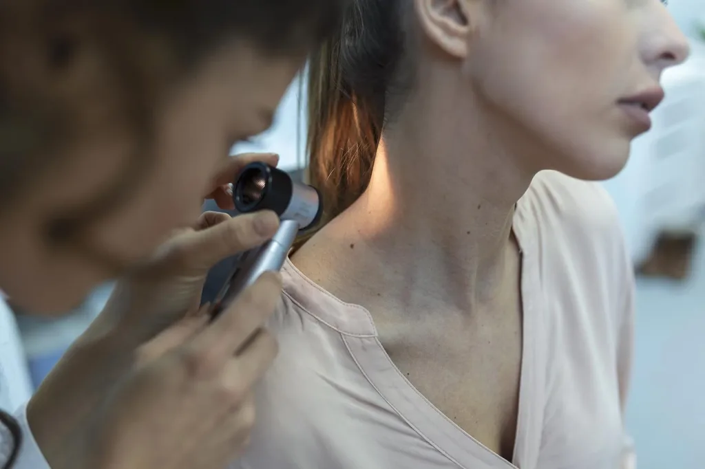 Ärztliche Untersuchung einer Hautveränderung mit einem Dermatoskop